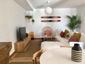 a living room with a white couch and a tv at Casa El Mero in La Herradura