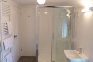 a bathroom with a shower and a sink at Dairy Cottage in Porthcawl