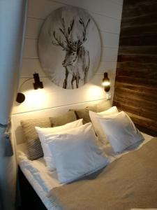 a bed with a picture of a deer on the wall at Apartment Suutarintie in Rovaniemi