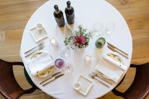 una mesa blanca con botellas de vino y copas. en Locanda La Raia, en Gavi