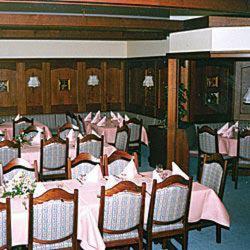 ein Esszimmer mit Tischen und Stühlen sowie einem rosa Tischtuch in der Unterkunft Häffner Bräu in Bad Rappenau