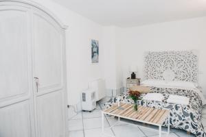 a white bedroom with a bed and a table at L' Ambasciata Gaeta in Gaeta