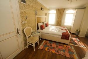 a bedroom with a bed and a chair and a door at Venue Hotel Istanbul Old City in Istanbul