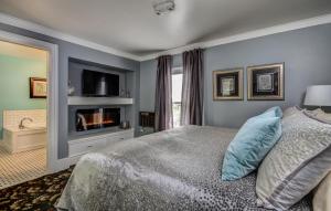 um quarto com uma cama com lareira e uma televisão em Twin Oaks Inn em Saugatuck