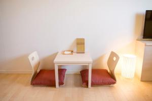 una mesa con dos sillas y una mesa con reloj. en HOTEL MYSTAYS Asakusabashi, en Tokio