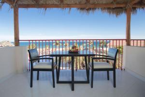 uma mesa e cadeiras numa varanda com praia em Grand Decameron Los Cabos, A Trademark All-Inclusive Resort em San José del Cabo