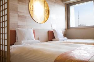 a white bed with a white comforter and pillows at HOTEL MYSTAYS Asakusabashi in Tokyo