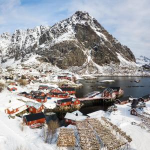 ein schneebedecktes Dorf mit einem Berg im Hintergrund in der Unterkunft Å Rorbuer by Classic Norway Hotels in Å