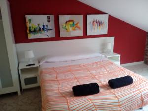 a bedroom with a bed, a desk and a painting on the wall at Albergue Aqua Portomarin in Portomarin