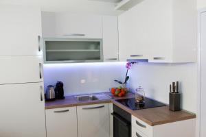 una cocina con armarios blancos y fregadero en Apartment Dina, en Karlovac