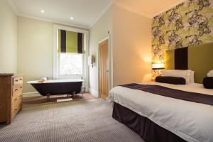 a hotel room with a bed and a bath tub at The Green House in Bournemouth