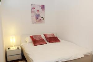 a bedroom with a white bed with two pillows on it at Apartment Dina, Self check in 0-24 in Karlovac