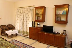 a living room with a flat screen tv and a chair at Savrupson Heritage Home in Jalandhar