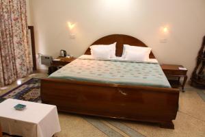 a bedroom with a large wooden bed with pillows at Savrupson Heritage Home in Jalandhar