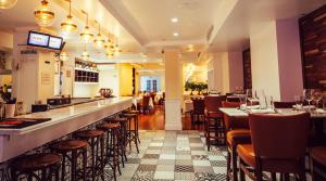a restaurant with a bar and some tables and chairs at San Carlos Hotel New York in New York