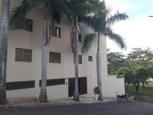 a building with two palm trees in front of it at Hotel Harmonia in Araras