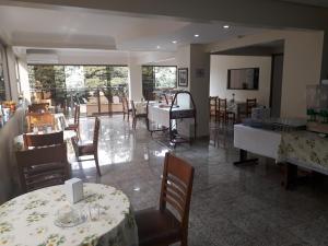 a dining room with tables and chairs and a restaurant at Hotel Harmonia in Araras