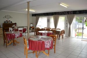 a restaurant with tables and chairs with red and white table cloth at Travel North Guesthouse in Tsumeb