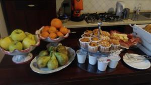 a table with bowls of fruit and muffins on it at Villa Casola B&B in Positano