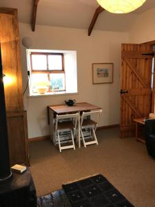 Zimmer mit einem Tisch, einem Fenster und einem Schreibtisch in der Unterkunft Eviedale Cottages in Evie