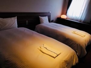 two beds sitting next to each other in a room at BRENZA HOTEL in Kobe