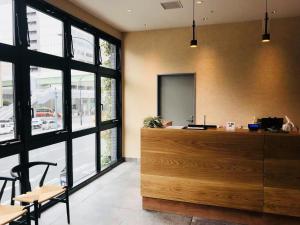 an office with a reception desk and tables and windows at BRENZA HOTEL in Kobe