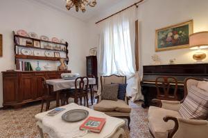 un soggiorno con tavolo e pianoforte di Mimì apartment with garden a Firenze