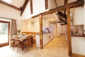 a kitchen and dining room with a table and chairs at Degwm in Llanwrin