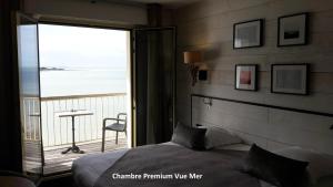 a bedroom with a bed and a view of the ocean at Hôtel Les Brises in La Rochelle