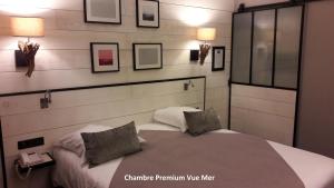 a bedroom with a bed with two pillows on it at Hôtel Les Brises in La Rochelle