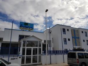 Un bâtiment blanc avec un panneau en haut dans l'établissement Apartmento Juana 2, à Puerto del Carmen