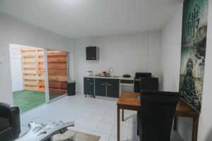 Buddha Studios Aruba في شاطئ بالم إيغل: مطبخ مع طاولة طعام ومطبخ مع باب