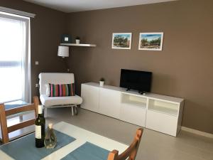 a living room with a television and a chair at Apartments Gazebo in Trogir