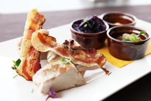 a plate of food with shrimp and dipping sauce at Warmthotel in Rome