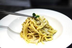 un piatto di pasta su un piatto bianco con una forchetta di Warmthotel a Roma