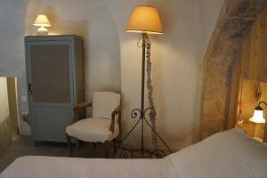 1 dormitorio con cama, lámpara y silla en la chambre d'hôte, en Lourmarin