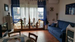 ein Wohnzimmer mit einem blauen Sofa und einem Tisch in der Unterkunft Monolocale Calamaiore in La Maddalena