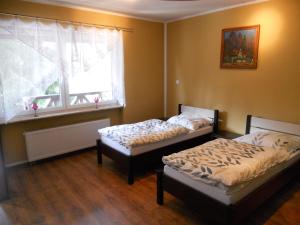 2 camas en una habitación con ventana en Apartament Turystyczny w Stepnicy, en Stepnica