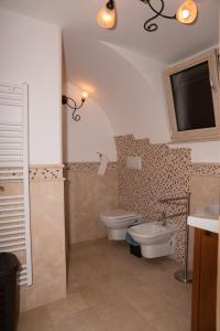 La salle de bains est pourvue de toilettes, d'un lavabo et d'une télévision. dans l'établissement Casa Jacqueline al borgo, à Giuliano
