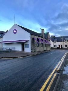 a large white building on the side of a street at The Inn @ Y-Not in Thurso
