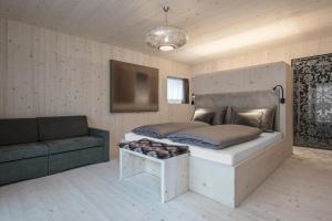 um quarto com uma cama grande e um sofá em Artefugium Atelier - Apartments em Selva di Val Gardena