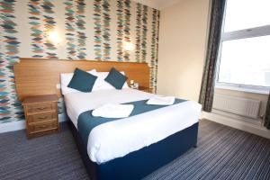 a hotel room with a bed and a window at TLH Victoria Hotel - TLH Leisure, Entertainment and Spa Resort in Torquay