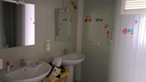 a white bathroom with a sink and a mirror at Macarìa Agricampeggio in Alliste