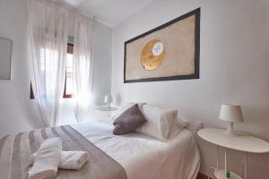 ToledoRooms Estrella - M, L, XL, XXL - Pisos con Azotea - Sun Terrace في طليطلة: غرفة نوم بيضاء مع سرير وصورة على الحائط