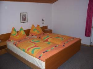 a bedroom with a large bed with a colorful comforter at Mairhof in Laion