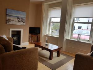 a living room with a coffee table and two windows at 7 Doolin Court in Doolin