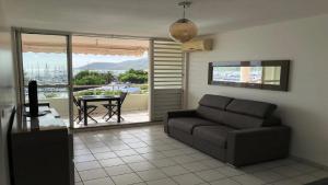 a living room with a couch and a table at Marin'a baie Martinique in Le Marin