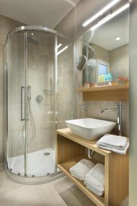 uma casa de banho com uma cabina de duche em vidro e um lavatório. em Jason Inn em Atenas