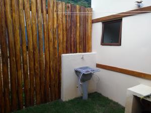 a wooden fence with a toilet next to a building at Casa Linda Ilhabela in Ilhabela