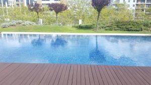 a large blue swimming pool with a wooden deck at The Galley in Lisbon